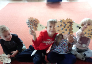 Dzieci pokazują wykonane z papieru jeże